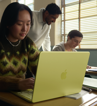 Estudante usando o MacBook Neo na cor amarelo-cítrico desconectado da tomada em uma sala de aula