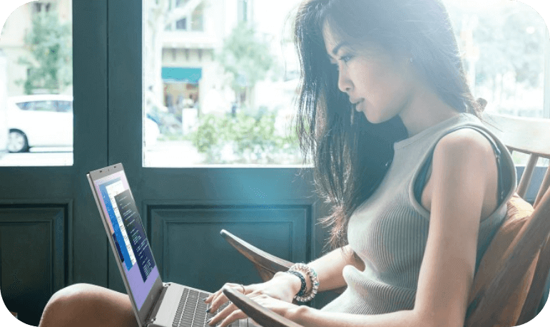 Uma mulher de cabelo preto sentada em uma poltrona mexendo em um notebook Acer